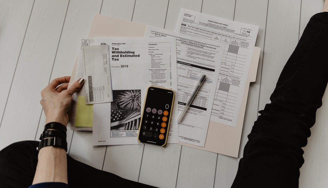 Bookkeeper reconciling figures with a calculator and printed ledger